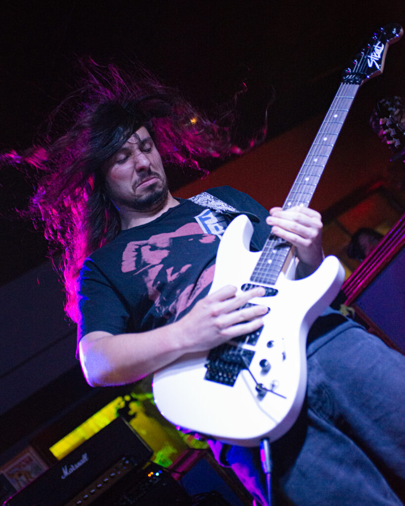 concert photography of Olathia guitarist at Beachland Tavern with white guitar and flowing hair